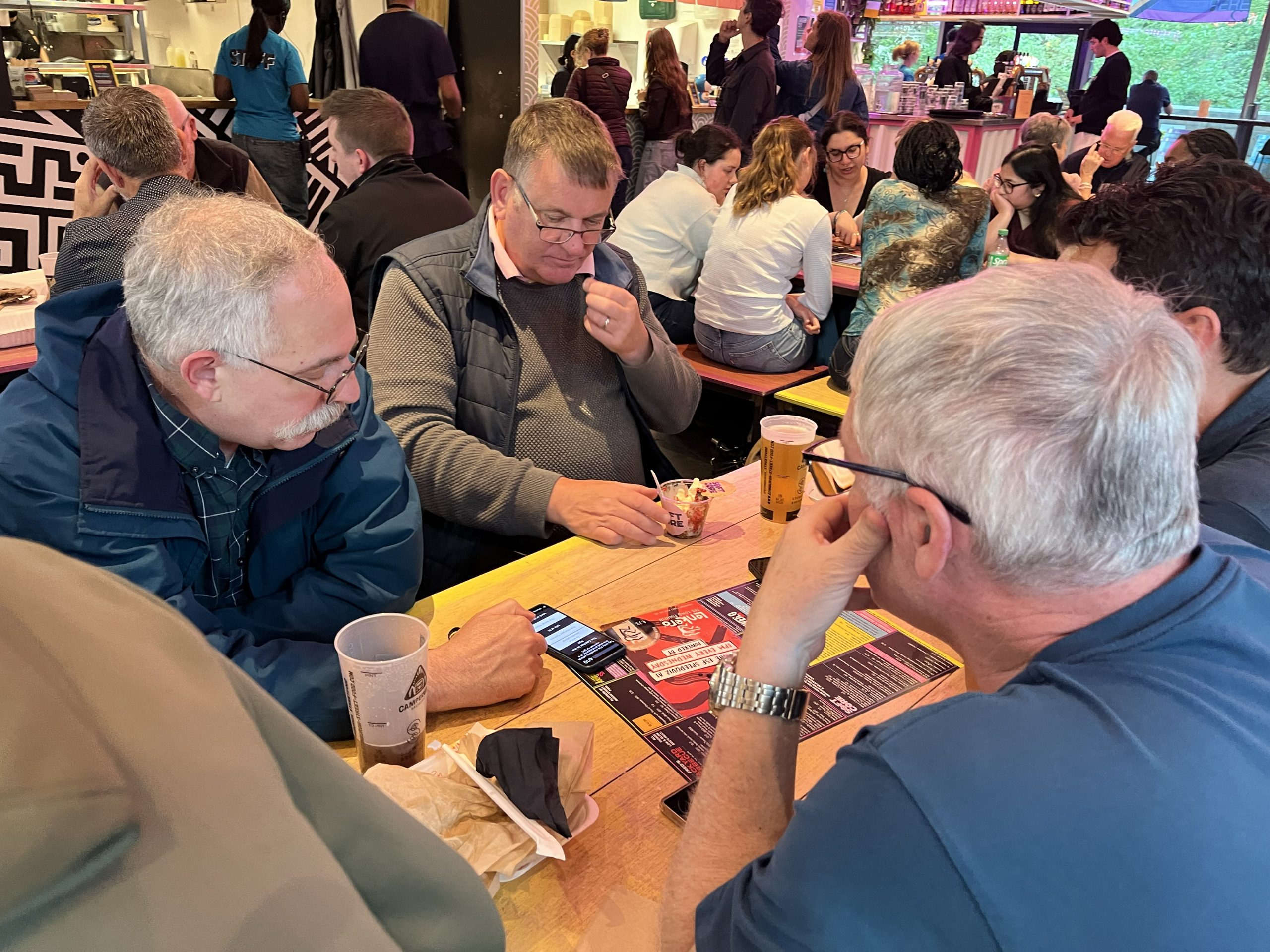 Three older players engaged in a SpeedQuizzing corporate quiz night at Edinburgh Street Food