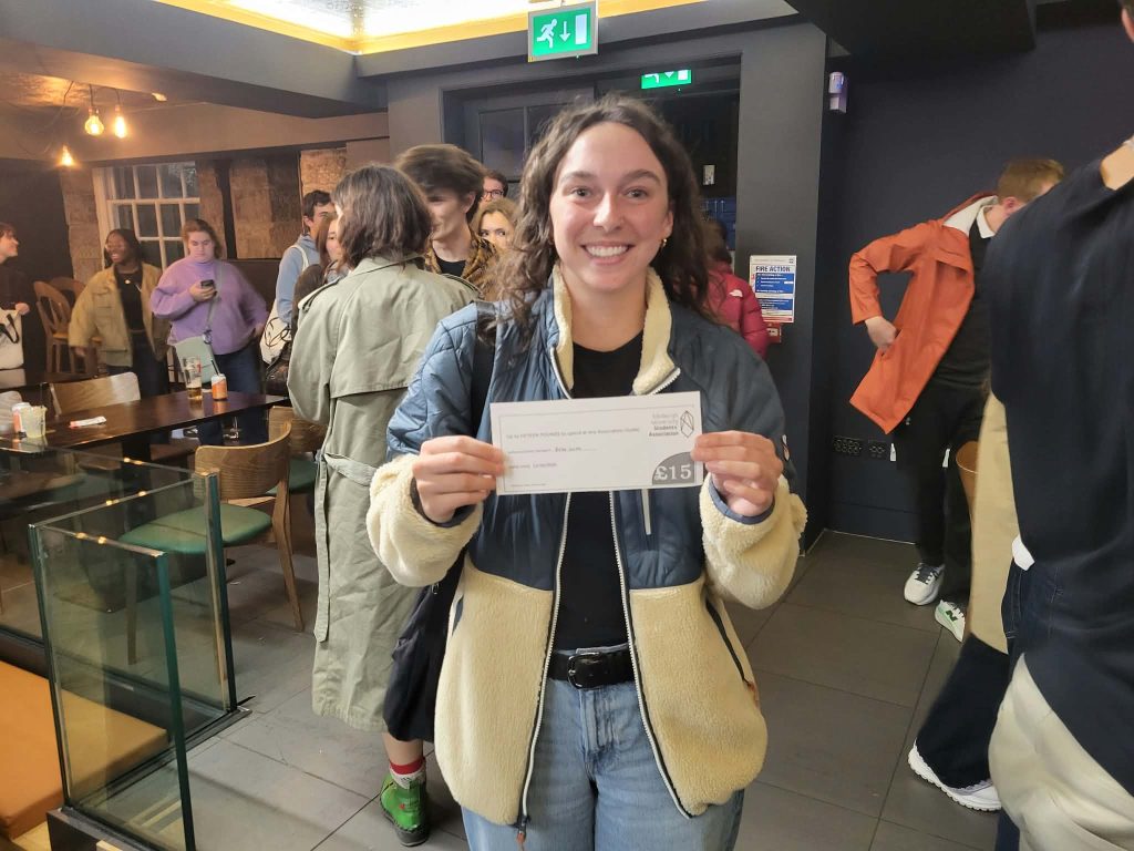Second-place team Genres of Confusion holding up their prize cheque at Premier SpeedQuizzing's quiz night at The Pleasance, Edinburgh